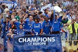 Chelsea players show off the Champions League trophy during an open-top bus parade along Kings Road in west London.