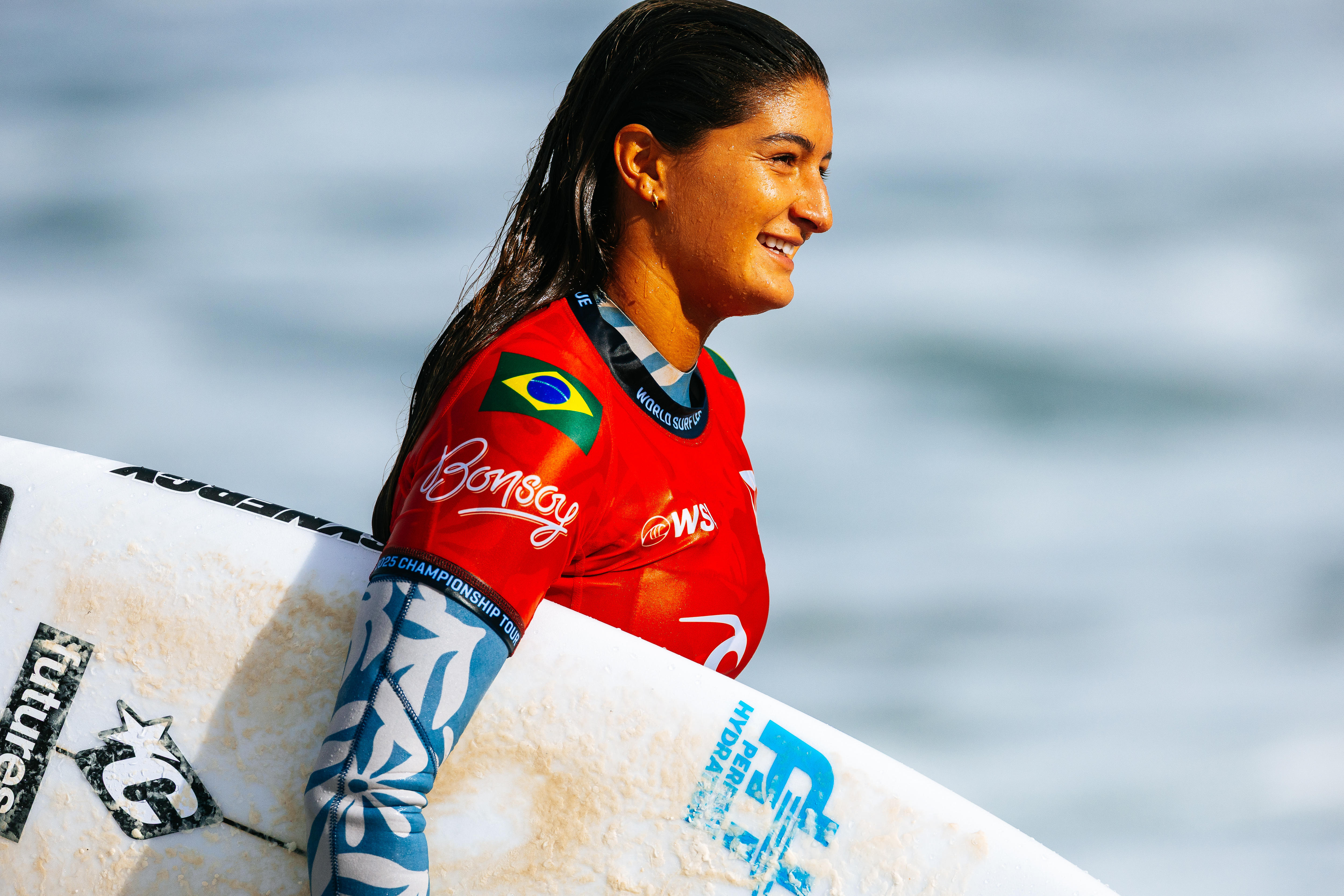 Luana Silva holding a surf board at the 2025 Bells Beach competition.