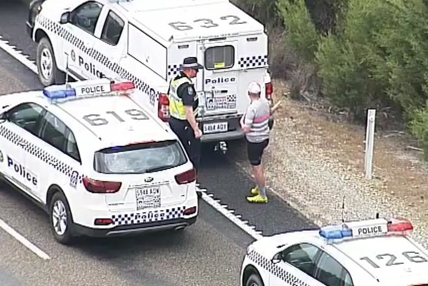 Image of three police cars and a police officer on the side of the Princes Highway.