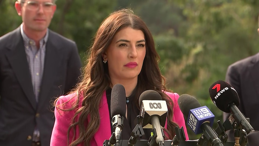 a woman standing behind microphones