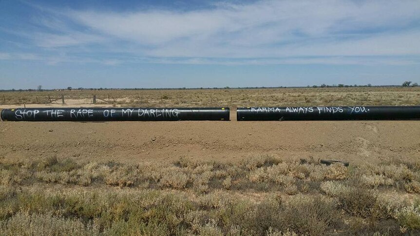 Two black pipelines lay outside and read stop the rape of my Darling.  Karma always finds you.