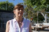 A woman in a white shirt standing on the main street of Margaret River, construction work is in background