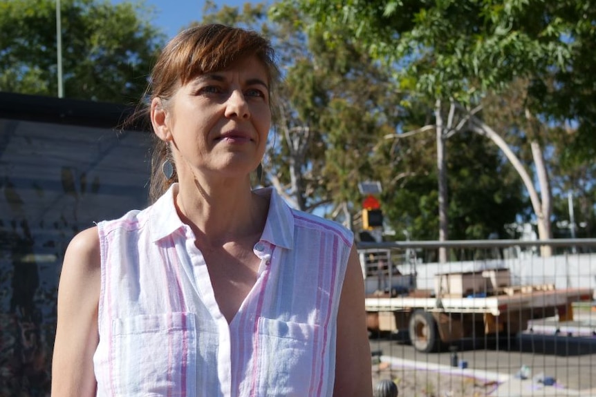 A woman in a white shirt standing on the main street of Margaret River, construction work is in background