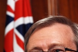 Kevin Rudd smiling with Australian flag in background