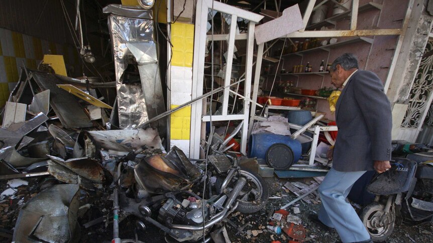 A man inspects at the site of a car bomb attack in Kerbala.