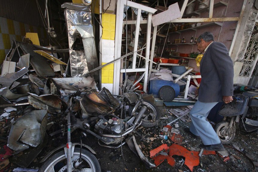 A man inspects at the site of a car bomb attack in Kerbala.