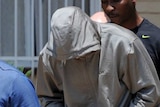 Oscar Pistorius (C) leaves the Boshkop police station to be taken into police custody.