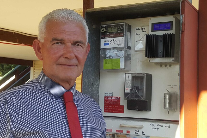 Paladin Solar Australia director Mark Robinson stands next to a meter box with a solar energy diverting device in it.
