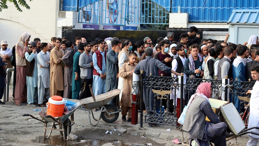 A long line of men outside a Kabul building 
