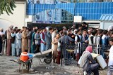A long line of men outside a Kabul building 
