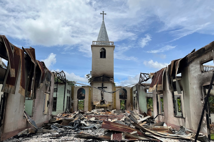 Una vista de una iglesia quemada con paredes carbonizadas y sin techo.