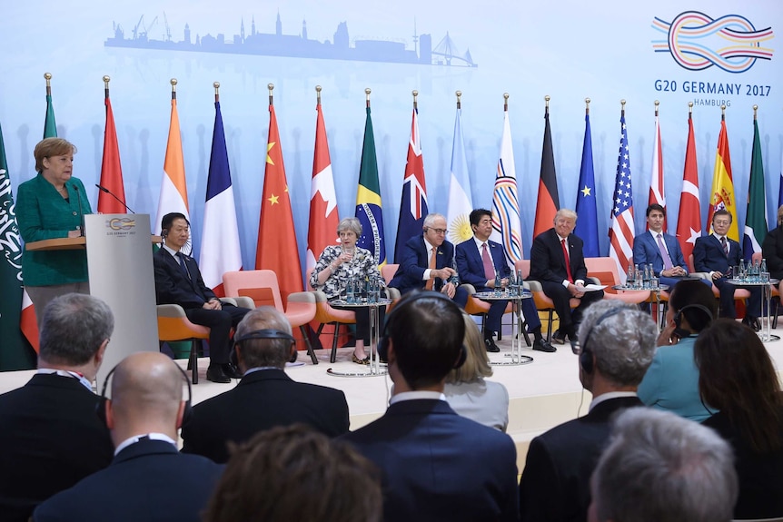 German Chancellor Angela Merkel (L) speaks during the panel discussion with other world leaders