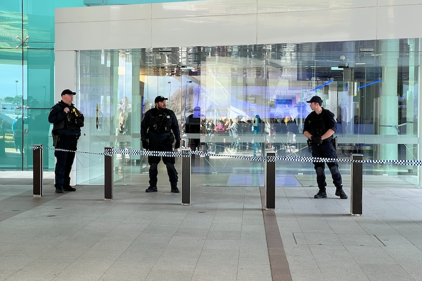 Police standing outside airport. 
