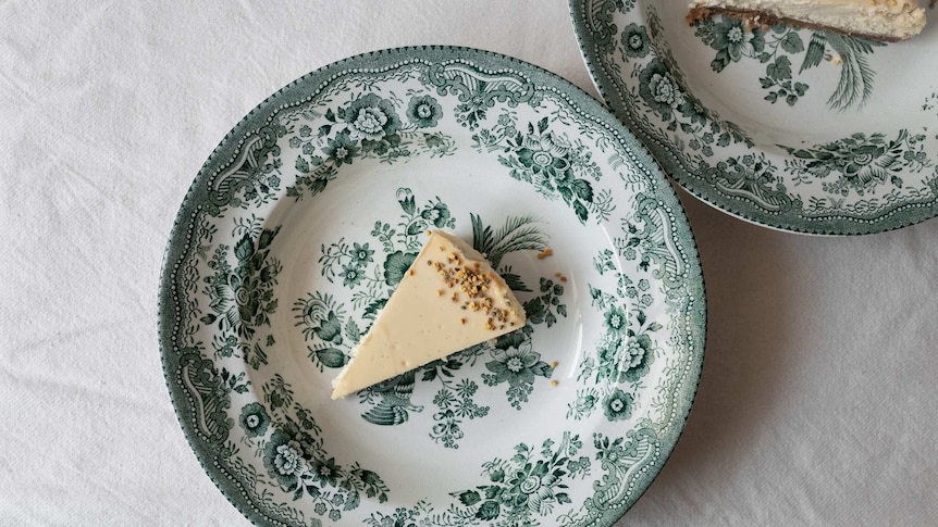 Slice of honey cheesecake on a patterned plate, topped with bee pollen and dried thyme, a light and creamy summer dessert recipe