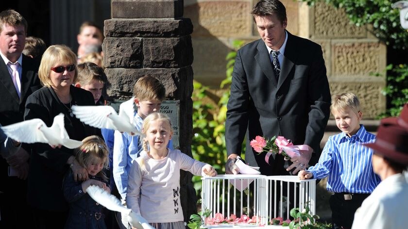 Glenn McGrath and his children, Holly and James, released doves in memory of their wife and mother.
