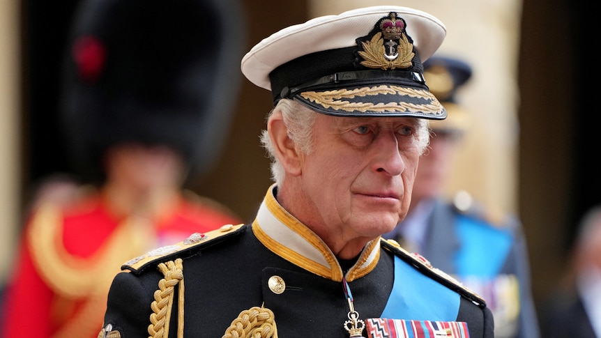 A close up of Prince Charles's face. He wears full military uniform with medals
