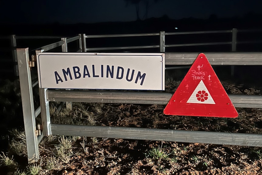 A nighttime picture of a gate to a cattle station