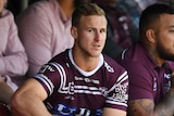 Daly Cherry-Evans sits in the Sea Eagles bench area with a large ice pace on his injured right ankle.