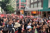 Hong Kong protesters dressed in black carry signs that read "Stop killing us".