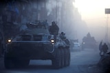 Russian soldiers ride on armoured vehicles through a street in Aleppo, Syria.