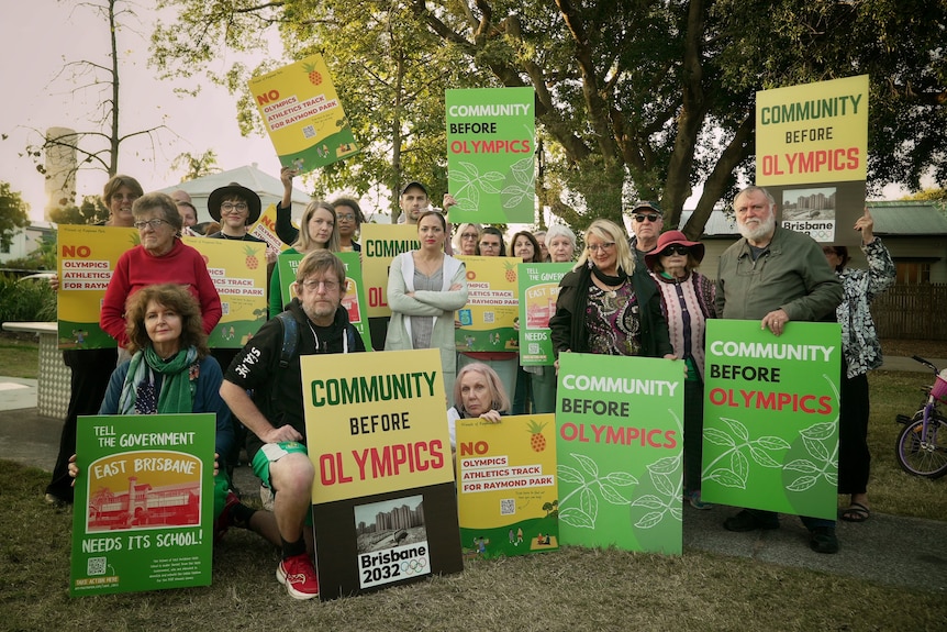 Locals hold signs to protest the redevelopment of the Gabba