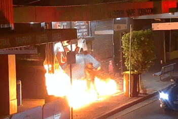 A burst of flame outside a tobacco shop.