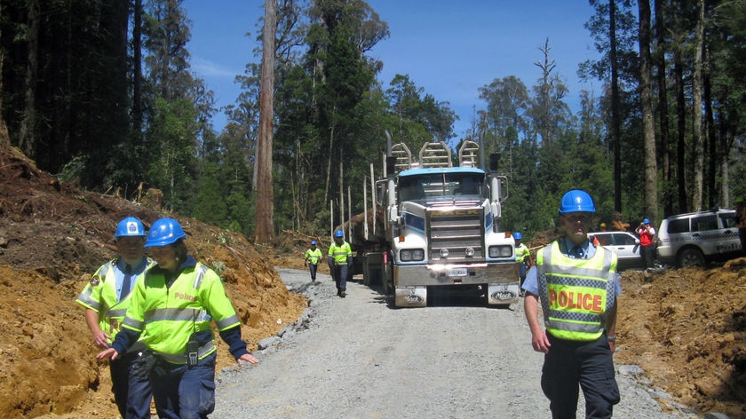 Tasmanian police escort a log truck out of the Upper Florentine Valley after a week of protests.