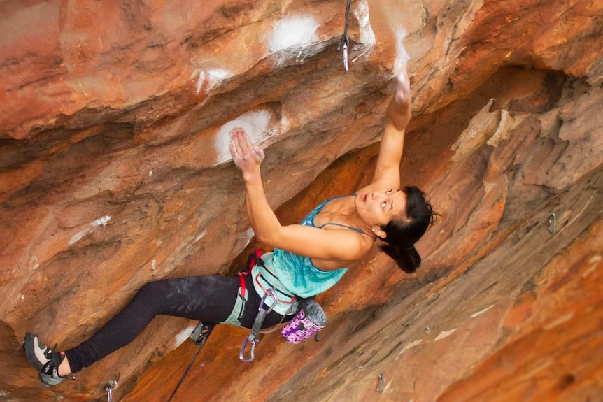 a female climber holding chalky rock walls in the Grampians