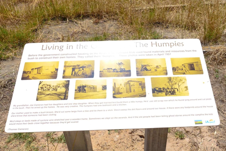 A sign in the bush featuring historical black and white photos and descriptions of life on the reserve