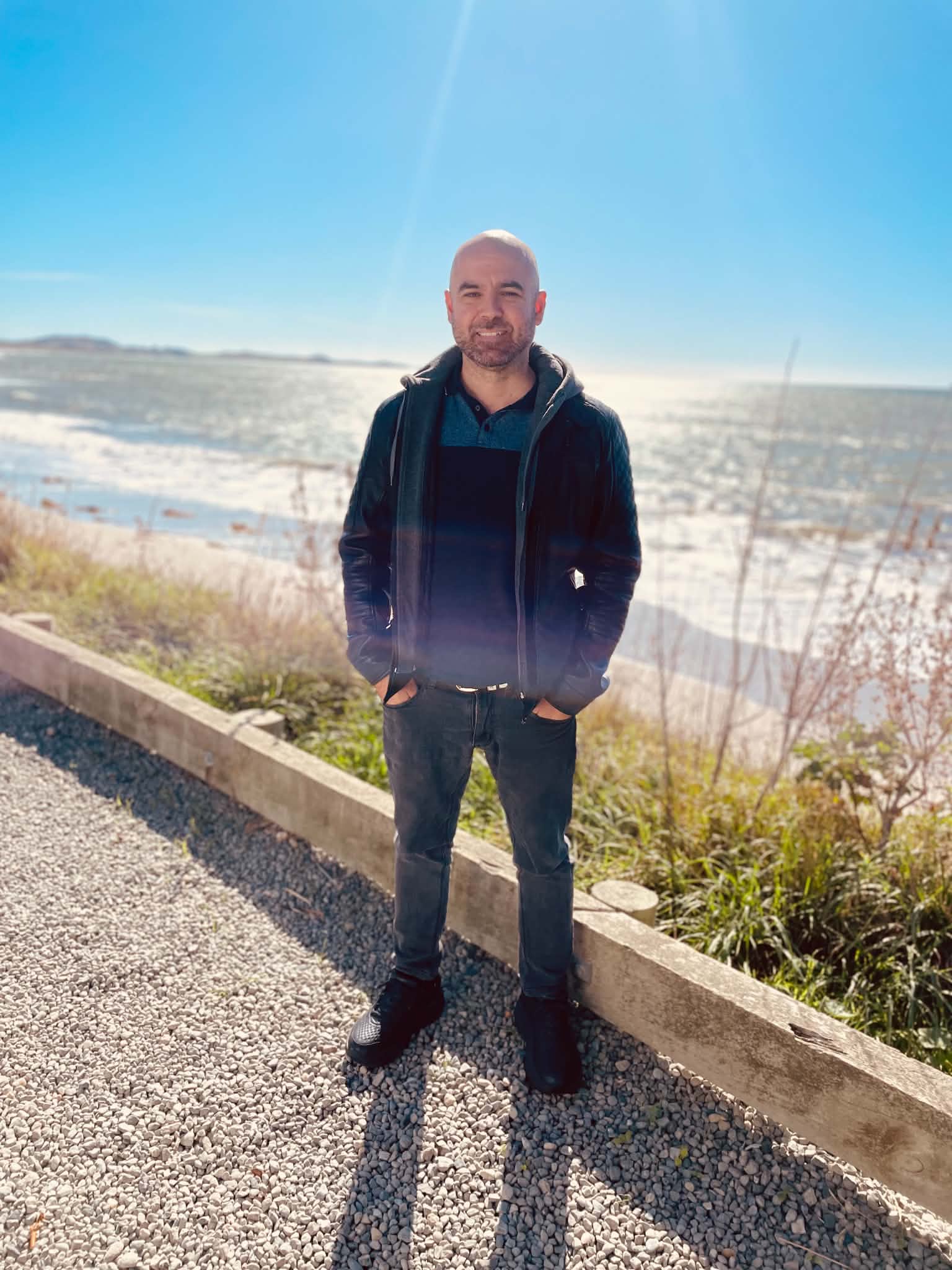 A 42-year-old man smiling at the beach