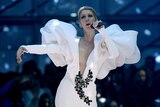 Celine Dion  singing in a white dress with large puffy sleavews