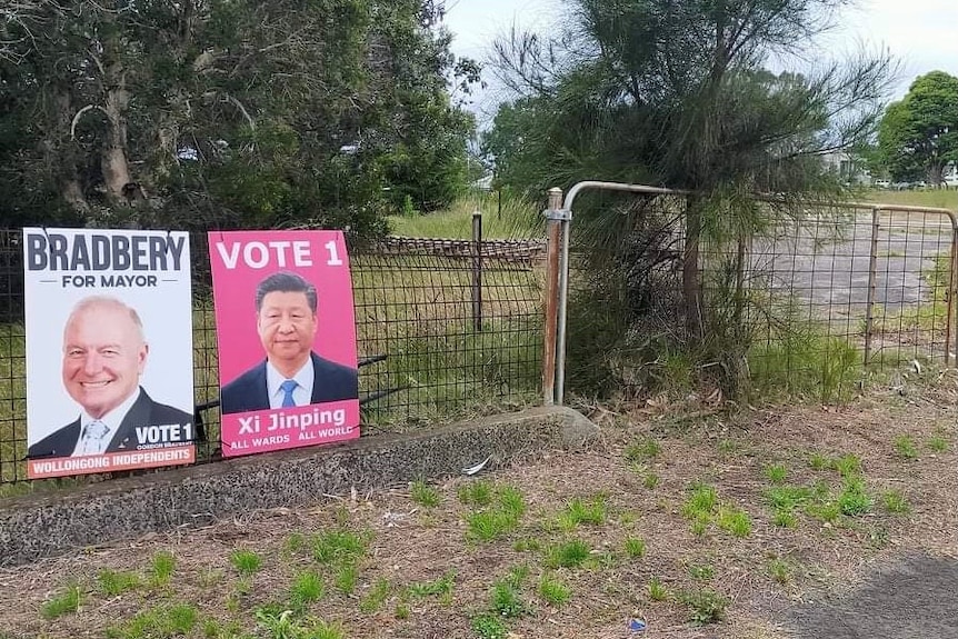 A fence with a campaign poster for Lord Mayor Gordon Bradbery, and one fake of China's President