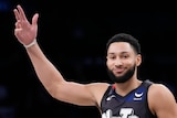 Ben Simmons puts his hand in the air and smirks during an NBA game for the Brooklyn Nets.