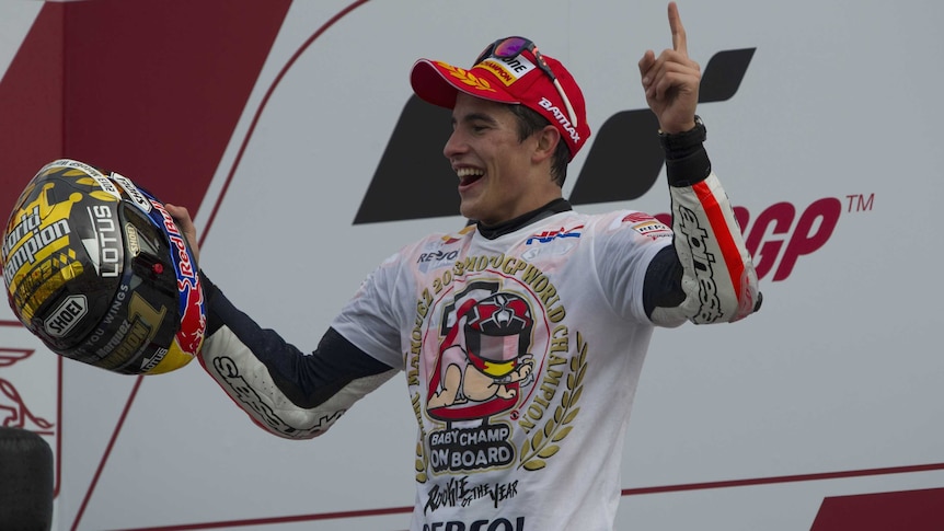 Marc Marquez celebrates on the podium after winning the MotoGP world title in Valencia.