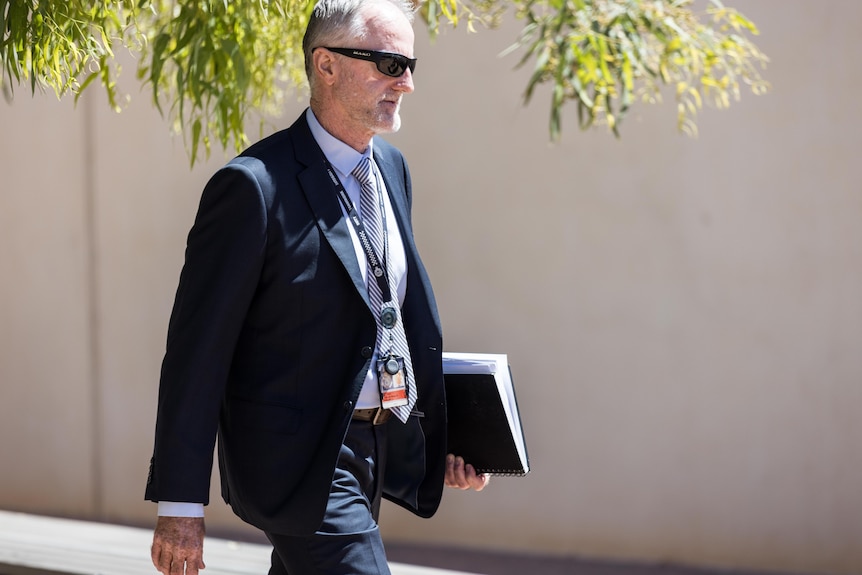 A police detective in a suit leaving court after testifying at trial.  