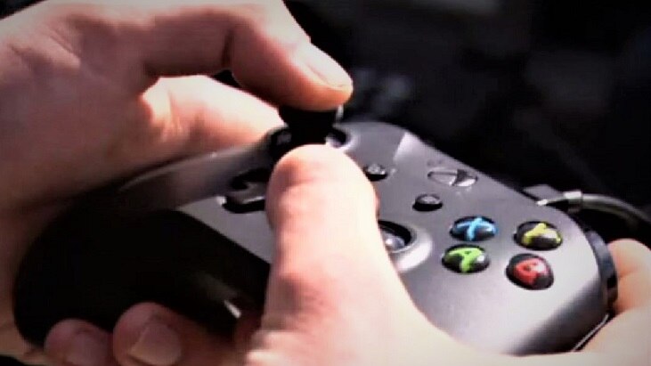 X-box controller being held by human hands.