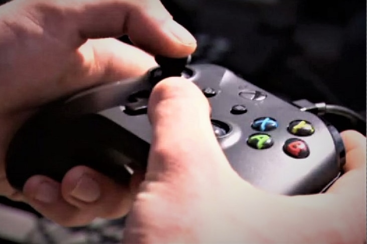 X-box controller being held by human hands.