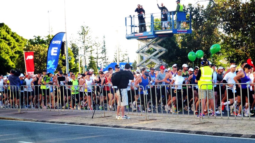 Competitors in the 2012 Gold Coast marathon run through the start gate.