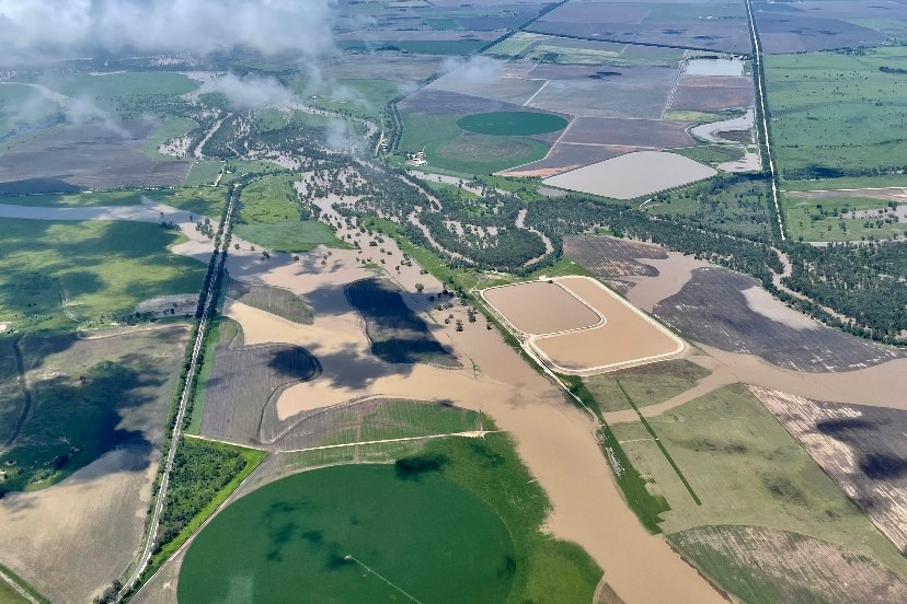 A drone shot of a river bursting its banks surrounded by farmland.