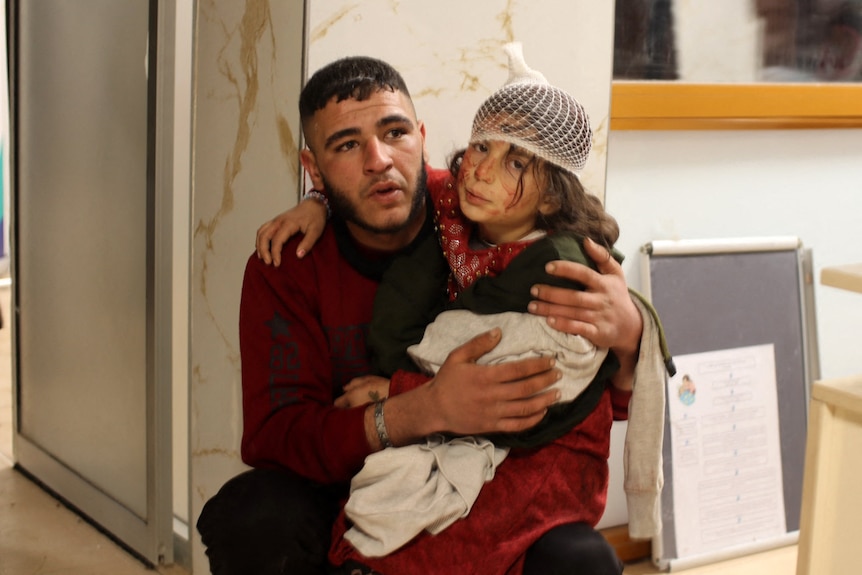 Man and a child sit in hospital after an earthquake