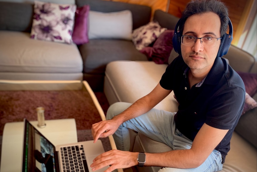Mohammad Makki sitting in his Figtree home with a laptop. 
