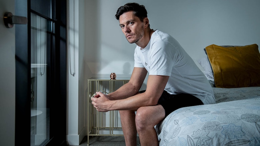 Rein Low sits on a bed in his home in Melbourne.