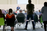 The view of a public meeting from the back.
