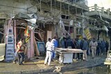 Residents gather at the site of a bomb attack in Alawi district, central Baghdad on December 22, 2011.