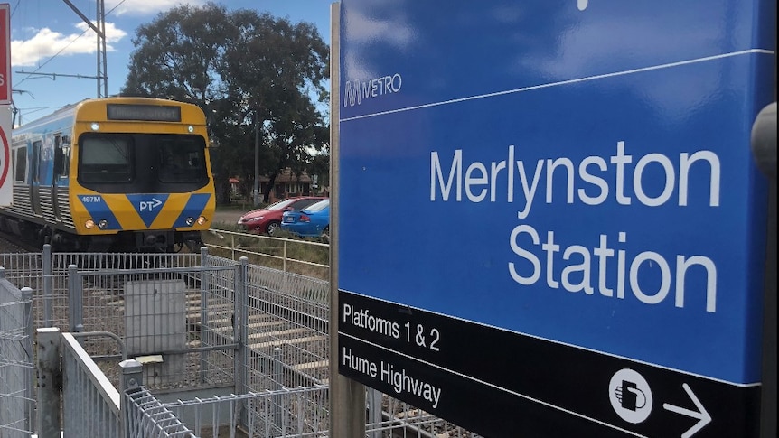 A close up of the blue and black Metro train sigh for Merlynston train station as a train approaches.