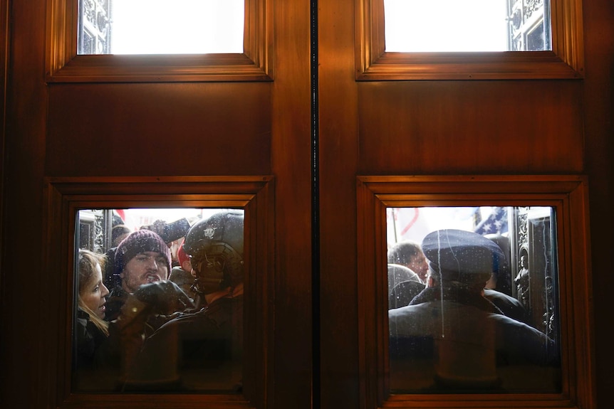 US Capitol Police try to hold back protesters outside the east doors to the House side of the US Capitol.