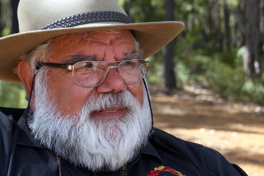 An indigenous man wearing a hat and glasses.