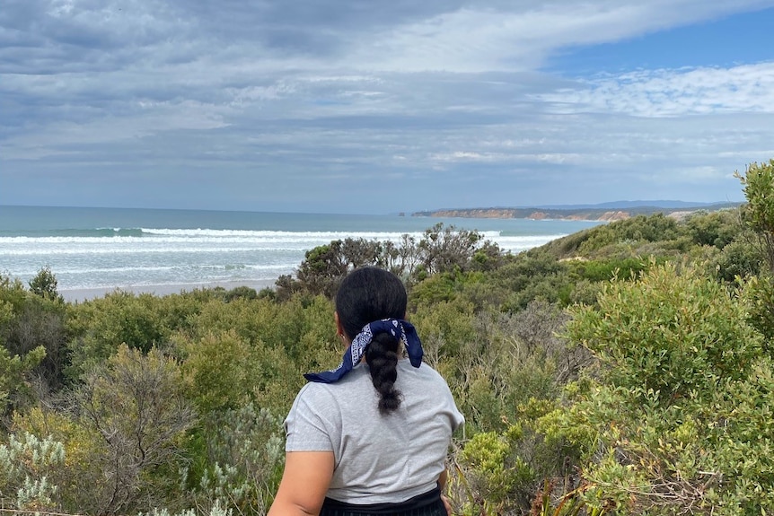 Back of a woman's head with the beach in the background.