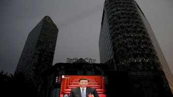 A public video screen shows Chinese President Xi Jinping.