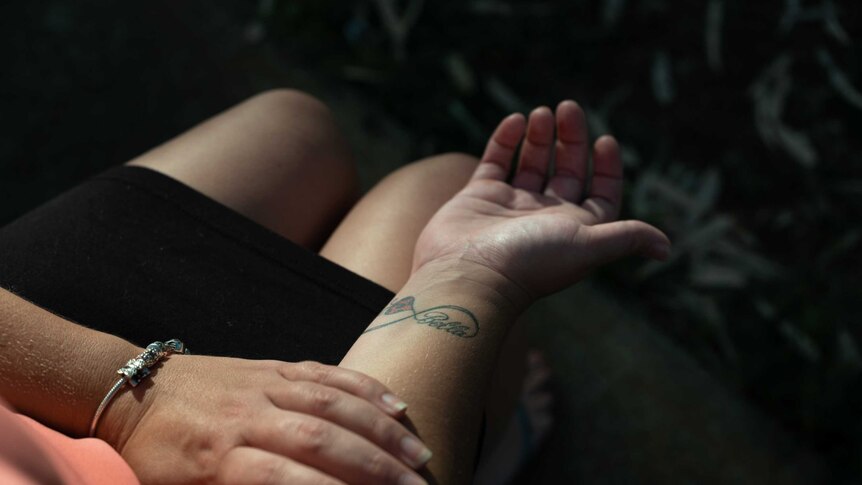 A close up shot of a woman's wrist tattoo which reads 'Bella'